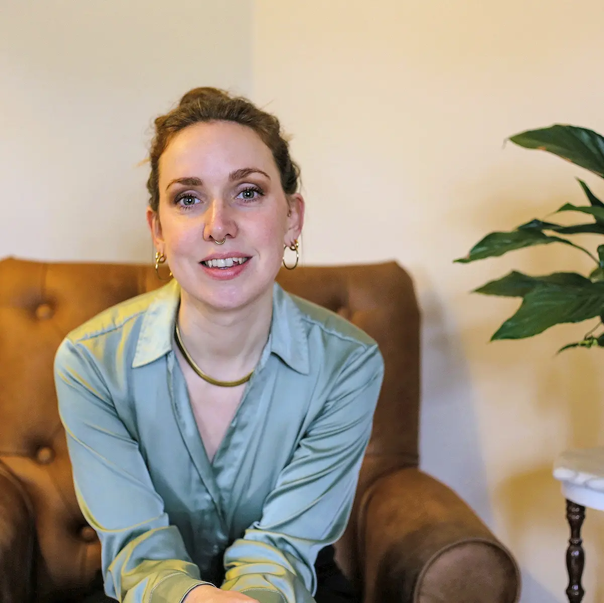 Woman in green blouse on leather armchair