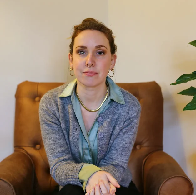 Woman sitting in brown leather armchair indoors